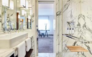 ein Bad mit einem Waschbecken und einem Spiegel in der Unterkunft InterContinental Genève, an IHG Hotel in Genf