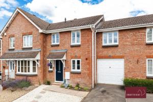 a red brick house with a white garage at Guildford - 3 Bedroom Home - Driveway & Garden in Guildford