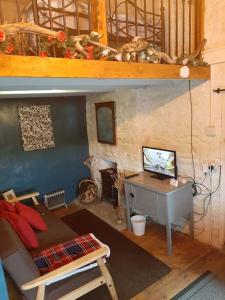 a living room with a table and a desk with a computer at Y Smithy in Llanybyther +14 photos