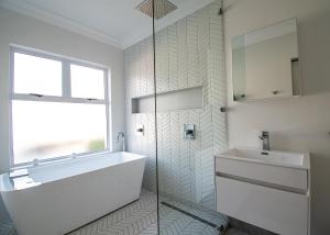 a bathroom with a tub and a sink and a window at 4 Sea Breeze Umhlanga Rocks in Umhlanga +7 photos