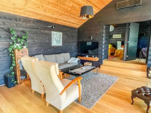 a living room with a couch and a fireplace at Holiday Home Villa aava by Interhome in Siksalo