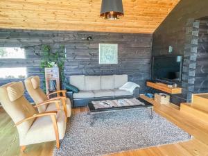 a living room with a couch and a tv at Holiday Home Villa aava by Interhome in Siksalo