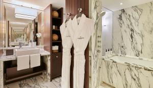 a bathroom with a robe hanging on a wall at InterContinental Genève by IHG in Geneva