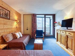 um quarto de hotel com uma cama e uma televisão em Apartment Chanteneige La Croisette-1 by Interhome em Les Menuires