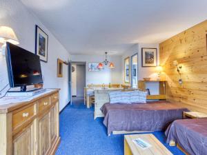 a living room with two beds and a flat screen tv at Apartment Chanteneige 505 by Interhome in Les Menuires +39 photos