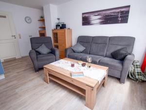 a living room with two couches and a coffee table at Apartment Fischerstube by Interhome in Norddeich
