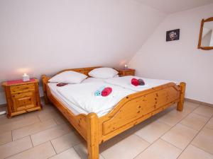 a bedroom with a wooden bed with two hats on it at Apartment Fischerstube by Interhome in Norddeich