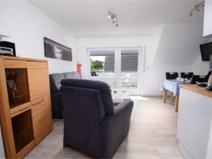 a living room with a chair and a table at Apartment Fischerstube by Interhome in Norddeich