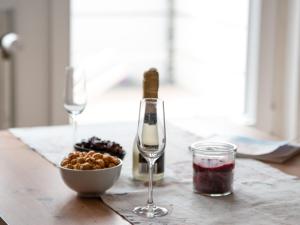 a table with a bottle of wine and a bowl of grapes at Apartment Fischerstube by Interhome in Norddeich +36 photos