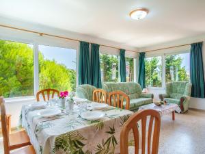 een eetkamer met een tafel, stoelen en ramen bij Holiday Home Carmen by Interhome in Punta Grossa