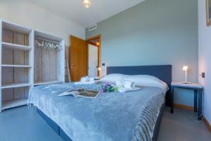 a bedroom with a large bed with a book on it at Residence degli Oleandri 2A in Argegno +32 photos