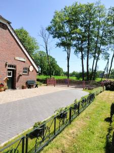 a stone walkway next to a brick building with benches at De Moane in Akelsbarg