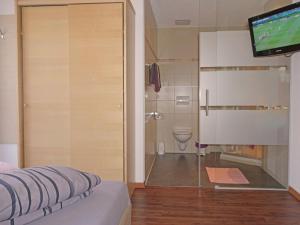 a room with a bathroom with a toilet and a television at Apartment Flirscherblick by Interhome in Flirsch