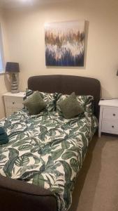 a bed with a green and white comforter in a room at Lovely 2 bed apartment sleeps 5 in Abingdon