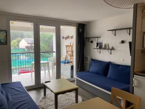 uma sala de estar com um sofá azul e uma varanda em Appartement Douarnenez Résidence en bord de plage em Douarnenez