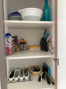 a kitchen shelf with utensils and other kitchen items at Appartement Douarnenez Résidence en bord de plage in Douarnenez +15 photos