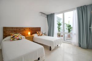 Atamaría的住宿－Two Bedroom Golf Bungalow On La Manga Club，酒店客房设有两张床和窗户。