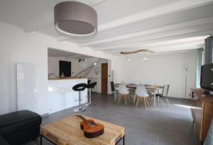 una sala de estar con una guitarra sobre una mesa de madera en Belle villa climatisée de 105m² en bord de mer., en Frontignan