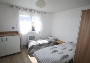 1 dormitorio con 2 camas y ventana en Belle villa climatisée de 105m² en bord de mer., en Frontignan