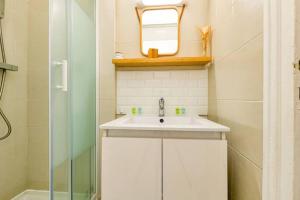 a bathroom with a sink and a mirror and a shower at Le Janet3 YourHostHelper in Grenoble