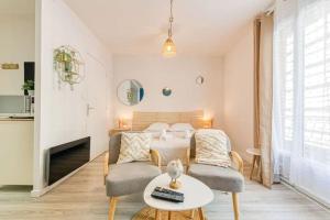 a bedroom with a bed and two chairs and a table at Le Janet3 YourHostHelper in Grenoble