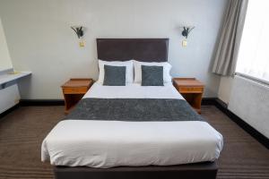 a hotel room with a large bed with two night stands at Wellow Hotel in Cleethorpes