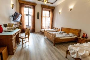 een slaapkamer met 2 bedden, een bureau en een tafel bij Friends Hostel & Apartments in Boedapest