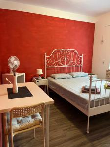 a bedroom with a bed with a red wall at LaRocca studio Apartments in Piran