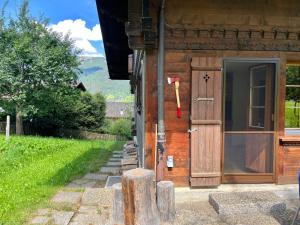 a door on the side of a wooden house at Apartment Akelei - gross by Interhome in Zweisimmen