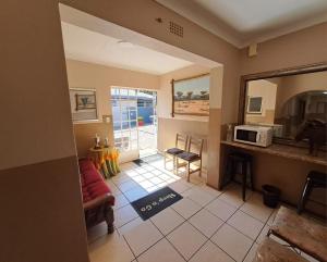 a living room with a red couch and a microwave at Sleep 'n Go Guesthouse in Mokopane