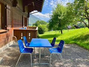 a blue table and chairs on a patio at Apartment Akelei - gross by Interhome in Zweisimmen
