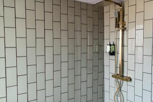 a bathroom with a shower with white tiled walls at High Tide in Redcar