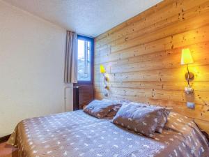 レ・メニュアールにあるApartment Chanteneige La Croisette-3 by Interhomeの木製の壁のベッドルーム1室(ベッド1台付)
