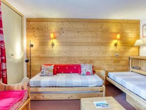 レ・メニュアールにあるApartment Chanteneige La Croisette-3 by Interhomeのベッド2台が備わる木製の壁の客室です。
