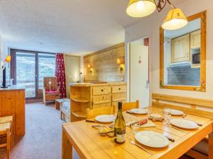 Una cocina con una mesa de madera con una botella de vino. en Apartment Chanteneige 301 by Interhome, en Les Menuires