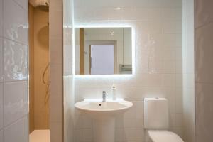 Un baño con lavabo, inodoro y espejo. en High Tide, en Milford on Sea 26 fotos más