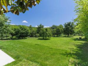 un parque con césped verde y árboles en un día soleado en Holiday Home Kotli by Interhome en Kotli