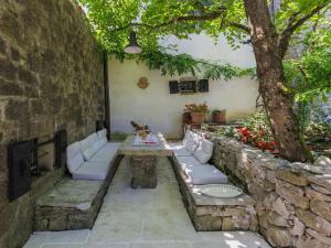 un patio con una pared de piedra y un árbol en Holiday Home Kotli by Interhome en Kotli