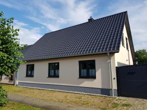 una casa blanca con techo negro en Ferienhaus Jerichow en Jerichow