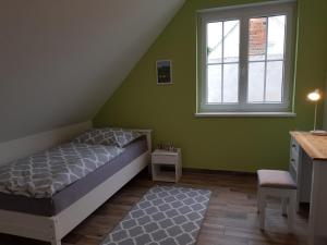Schlafzimmer mit einem Bett, einem Schreibtisch und einem Fenster in der Unterkunft Ferienhaus Jerichow in Jerichow