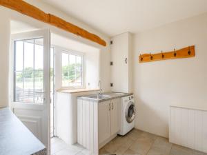 a laundry room with a washing machine and a window at Holiday Home Bryniel by Interhome in Sarn