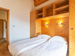 uma cama num quarto com uma parede de madeira em Apartment T-Resort La Tzoumaz 2p4 by Interhome em La Tzoumaz