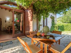 a patio with a wooden table and chairs at Holiday Home Casale Colomba by Interhome in Case dʼAmico