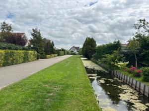 una carretera que conduce por una calle con un río en Holiday Home de Witte Raaf-3 by Interhome en Noordwijkerhout