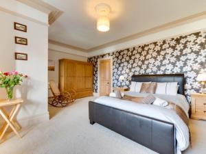 クーム・マーティンにあるHoliday Home Craigmore by Interhomeの花柄の壁紙を用いたベッドルーム1室(大型ベッド1台付)