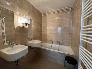 a bathroom with a sink and a bath tub at Holiday Home Bungalowpark Landsrade-1 by Interhome in Gulpen