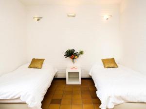 2 camas en una habitación con paredes blancas en Holiday Home Bungalowpark Landsrade-1 by Interhome, en Gulpen