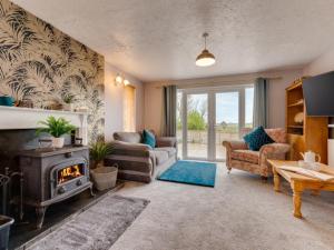 a living room with a fireplace and a stove at Holiday Home Monte Gordo by Interhome in Padstow