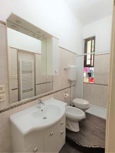 ein Badezimmer mit einem Waschbecken, einem WC und einem Spiegel in der Unterkunft Palagi Suite in Bologna