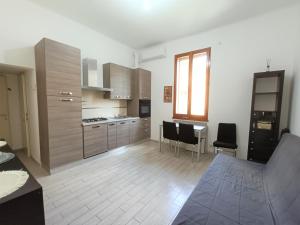 eine Küche mit Holzschränken sowie einem Tisch und Stühlen in der Unterkunft Palagi Suite in Bologna